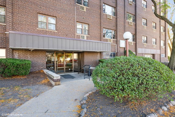 Front view of a multi-story brick building with a glass entrance.