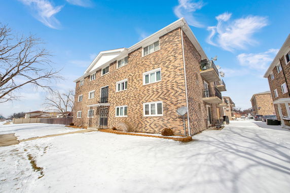 Front view of a multi-story brick apartment building.