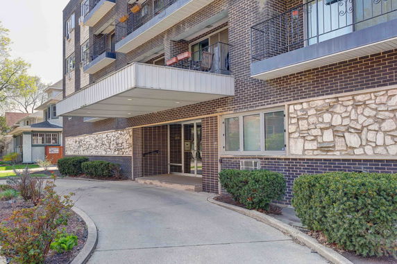 Front view of a multi-story brick building with balconies.