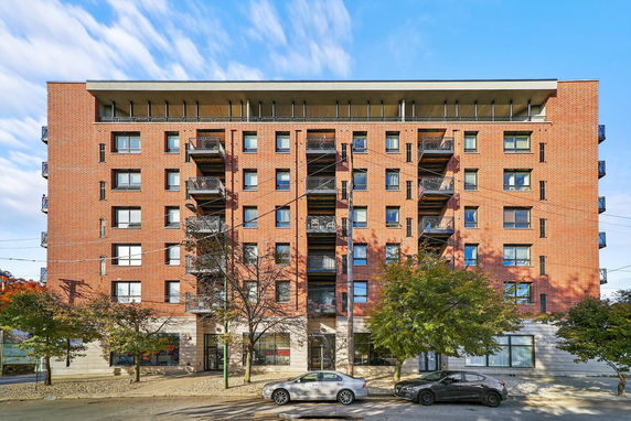 Front view of a multi-story brick building with balconies.