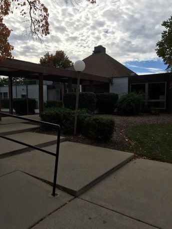 Front view of a low-rise building with a unique roof design.
