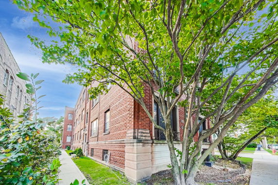 Corner view of a brick apartment building with multiple windows.