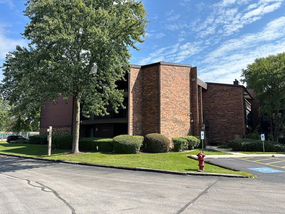 Front view of a brick apartment building with multiple levels.