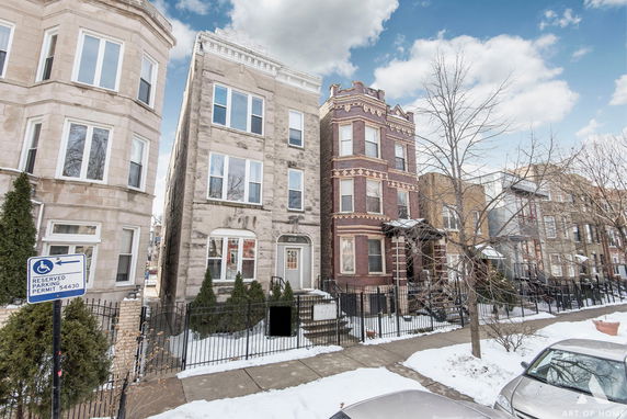 Front view of adjacent multi-story residential buildings on a snowy street.