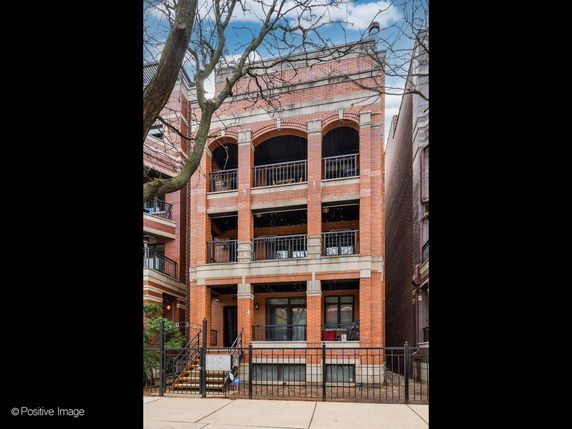 Front view of a multi-story brick building with balconies.