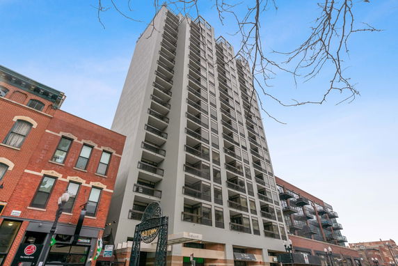 Front view of a tall residential building with balconies.
