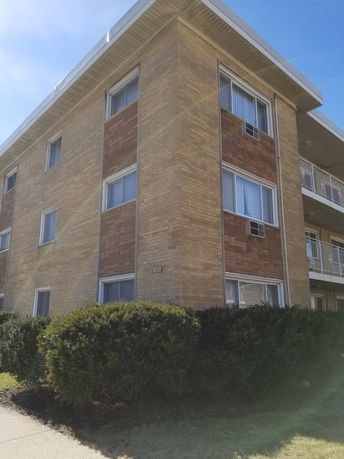 Front view of a three-story brick apartment building.