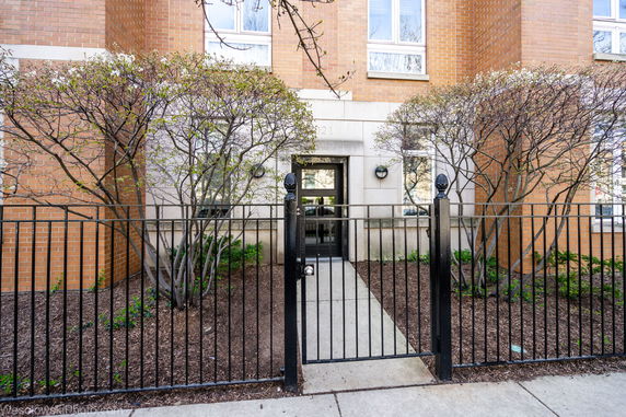 Front view of a brick building with a gated entrance.