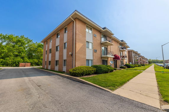 Front view of a multi-story apartment building with balconies.