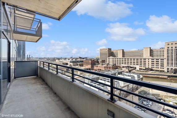Panoramic balcony view from a high-rise building overlooking urban architecture and a water channel.