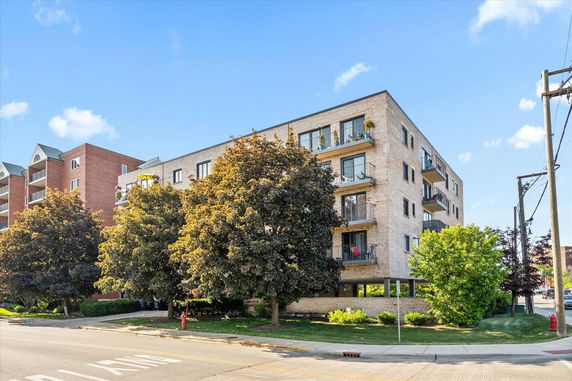 Front view of a multi-story apartment building with balconies.