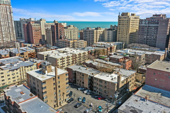 Elevated panoramic view of a cityscape with multiple buildings and a distant view of the water.
