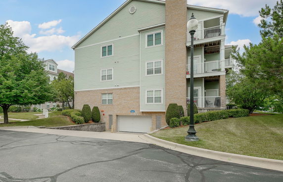Front view of a multi-story building with balconies and a garage entrance.