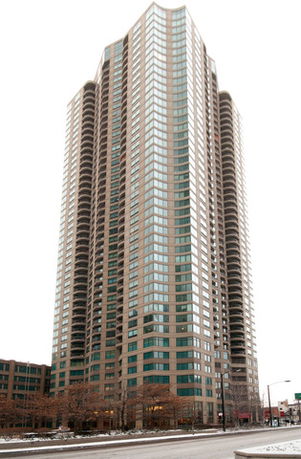 Front view of a tall residential building with multiple floors and balconies.
