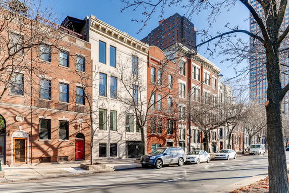 Front view of a row of multi-story brick and stone buildings on a city street.