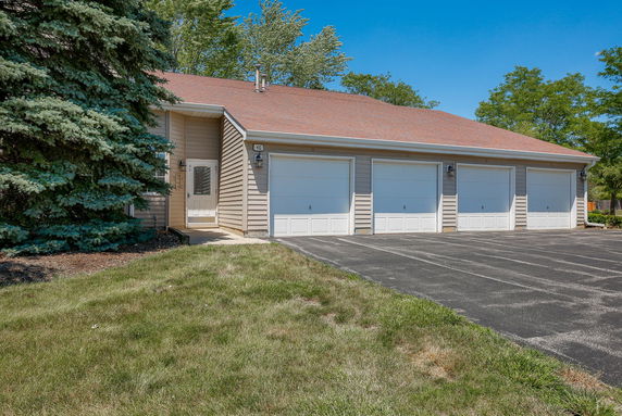 Front view of a building with multiple garage doors and a side entrance.