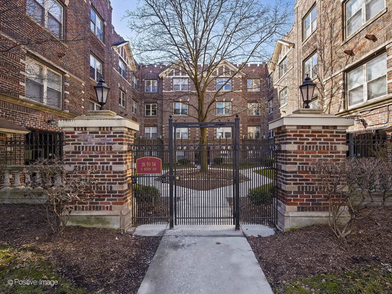 Front view of a brick residential building with gated entry.