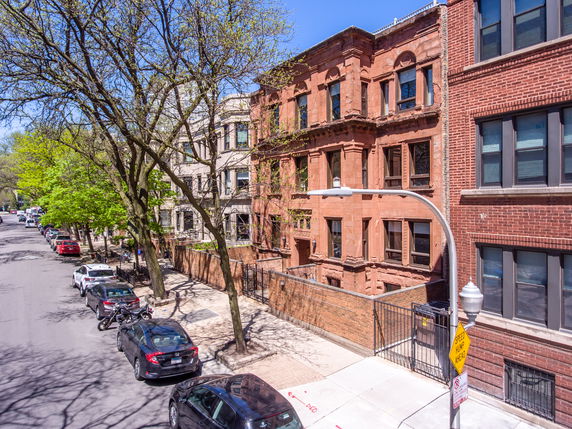Front view of a row of multi-story brick buildings along a street.