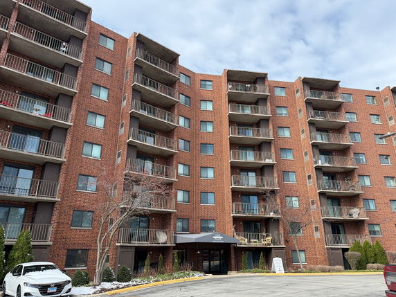 Front view of a multi-story apartment building with balconies.
