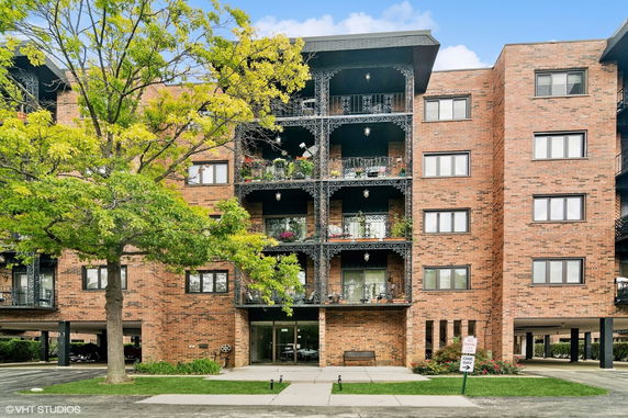Front view of a multi-story brick building with balconies.