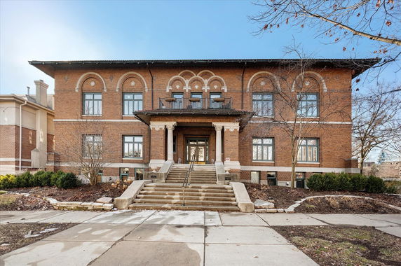 Front view of a two-story brick building with a central entrance and symmetrical windows.