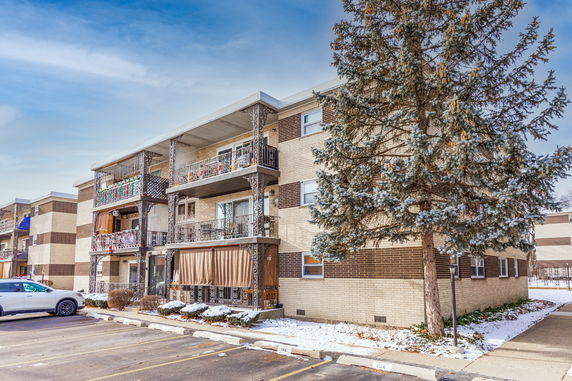 Front view of a three-story apartment building with balconies.