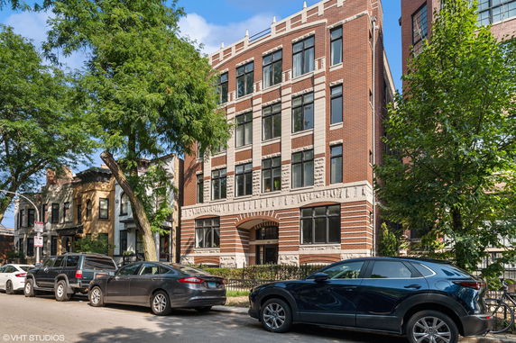 Front view of a multi-story brick building with multiple windows.