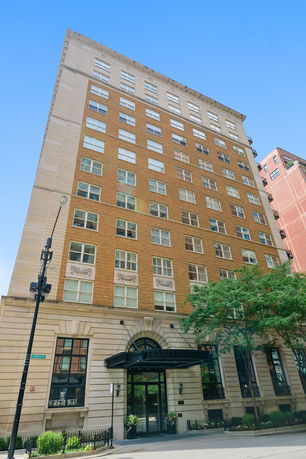 Front view of a multi-story brick building with large windows.