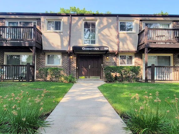 Front view of a two-story apartment building with balconies.