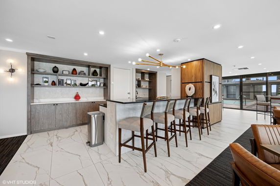 Interior view of a modern clubhouse with bar seating and decorative shelving.