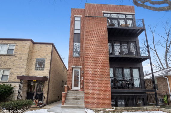 Front view of a multi-story brick building with balconies.