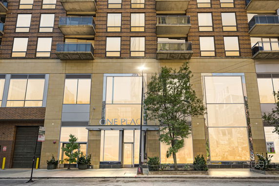 Front view of a multi-story building with balconies and large windows