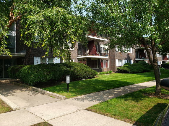 Front view of a multi-story apartment building with balconies.