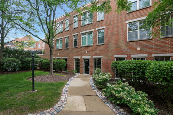 Front view of a brick three-story building with multiple windows.