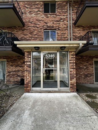 Front view of a multi-story brick building with balconies.