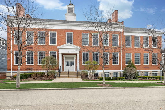 Front view of a large brick building with multiple windows and a central entrance.