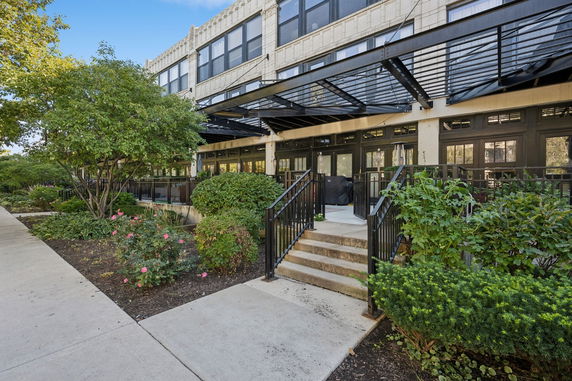Front view of a multi-story building with large windows and metal awnings.