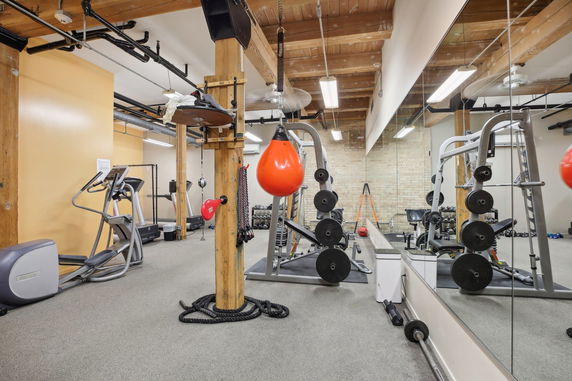 Indoor gym area with exercise equipment and mirrors.