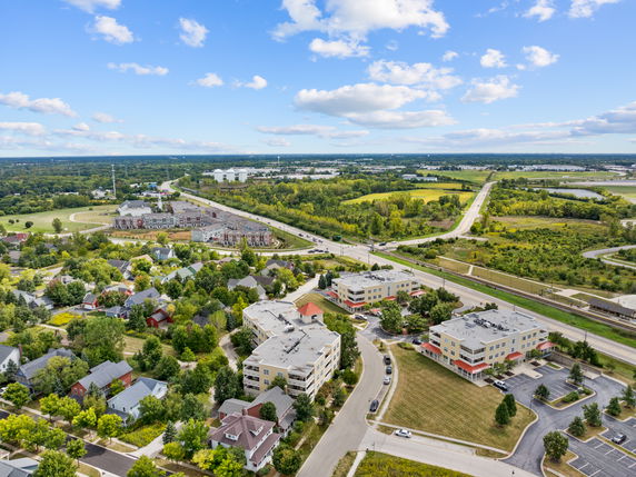 Wide-angle view of a suburban area with residential buildings, roads, and greenery in the landscape.