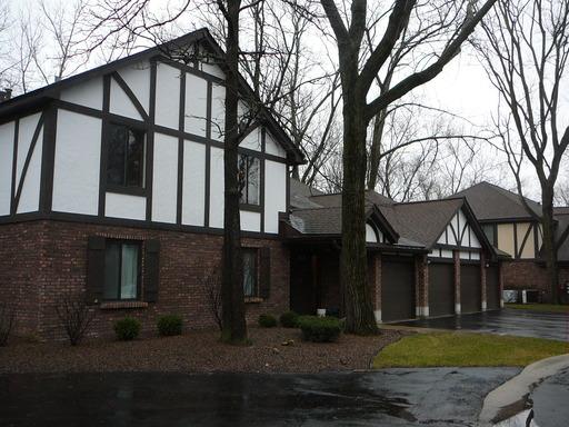 Front view of a two-story house with timber framing and a multi-car garage.