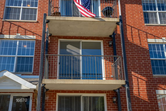 Front view of a multi-story building with a balcony.
