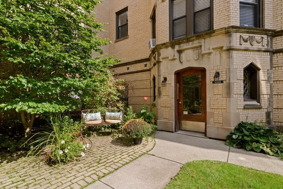 Front view of a brick building entrance with decorative stonework.