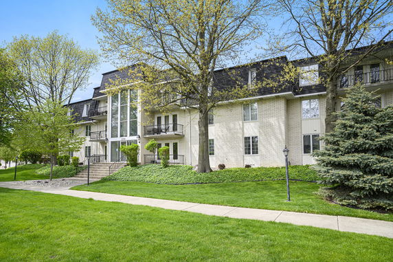 Front view of a multi-story building with balconies and large glass windows.