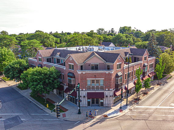 Front view of a multi-story brick commercial building on a street corner.