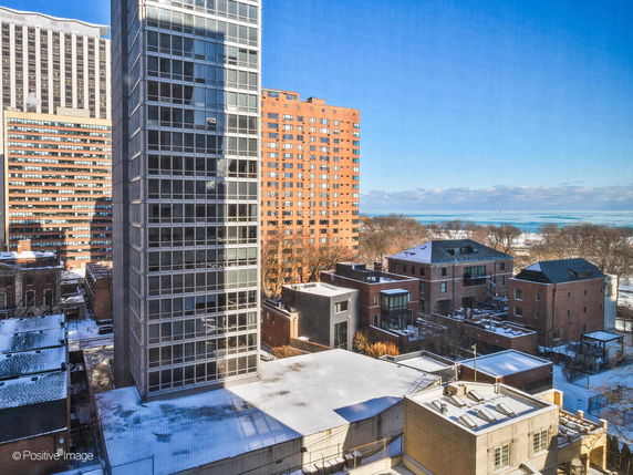View of multiple buildings with a nearby water body in the background.