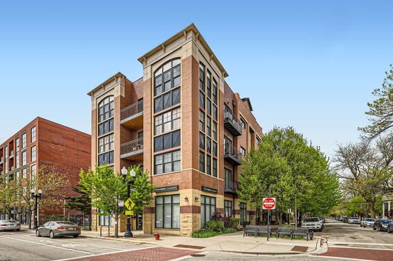 Front view of a multi-story brick building on a street corner.