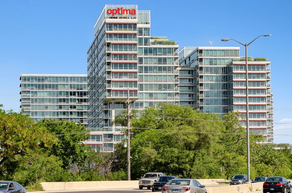 Front view of a modern multi-story glass building with multiple sections.