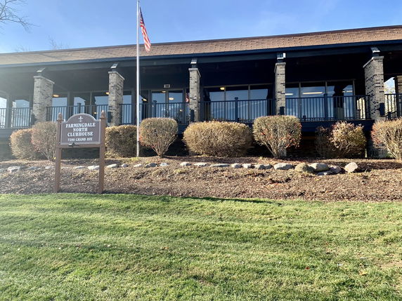 Front view of a building with a porch and sign that reads 'Farmingdale North Clubhouse'.