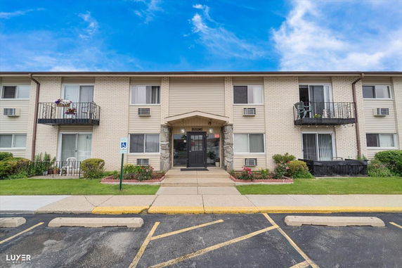 Front view of a two-story apartment building with balconies and a main entrance.