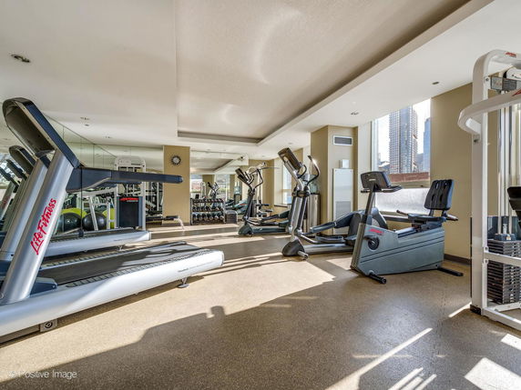 Indoor gym area with exercise equipment including treadmills and stationary bikes.